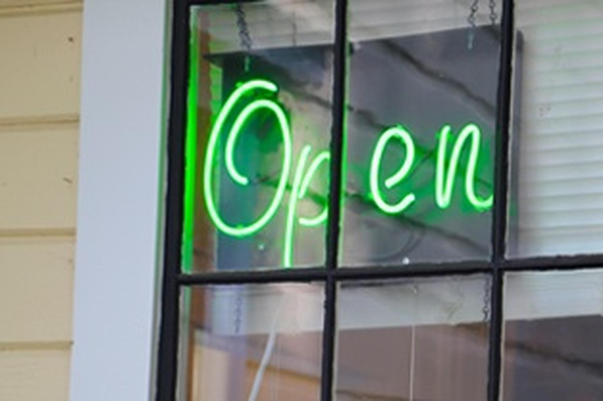 neon green open sign in window