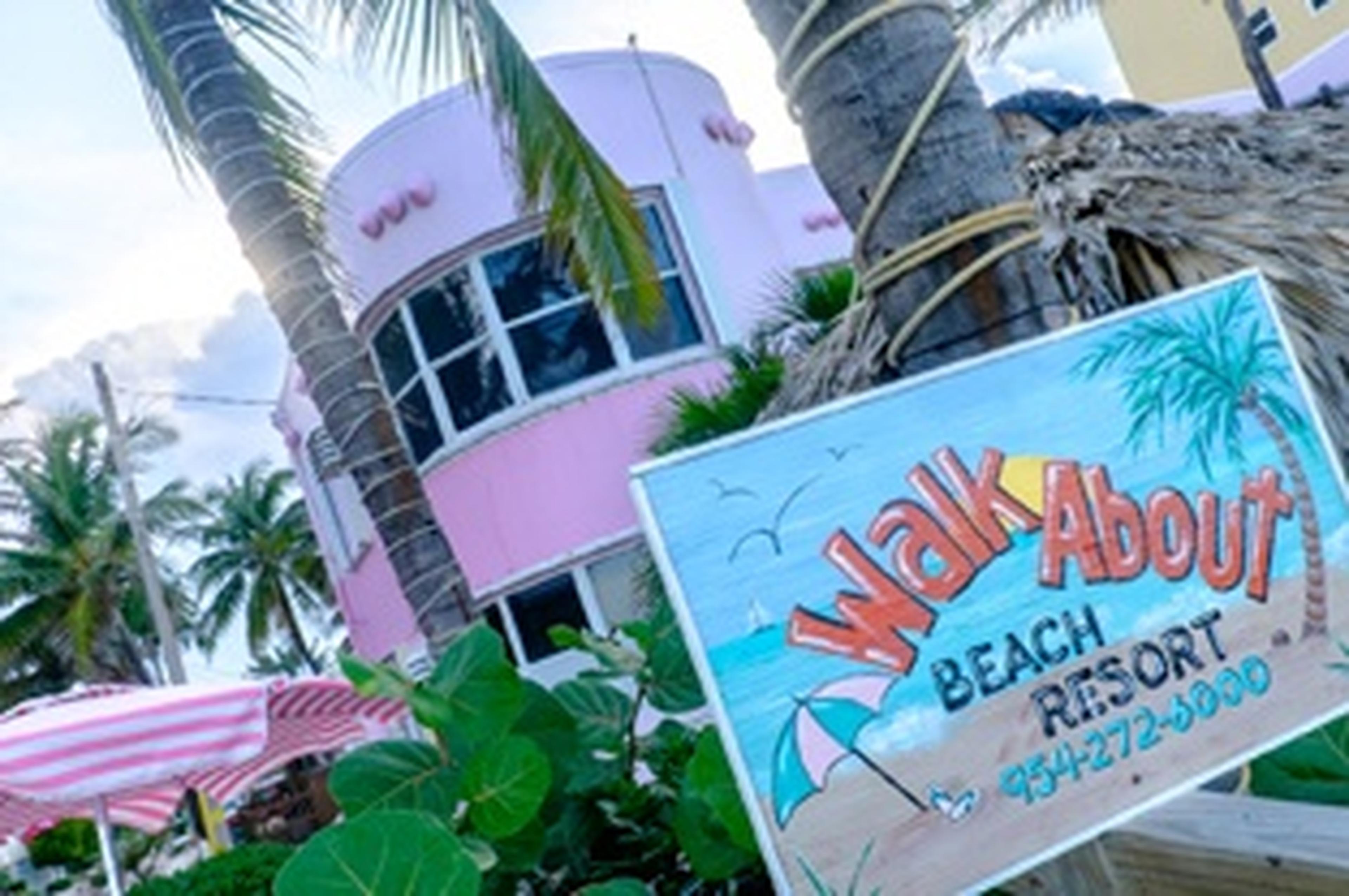 pink beach resort with sign that says walk about beach resort