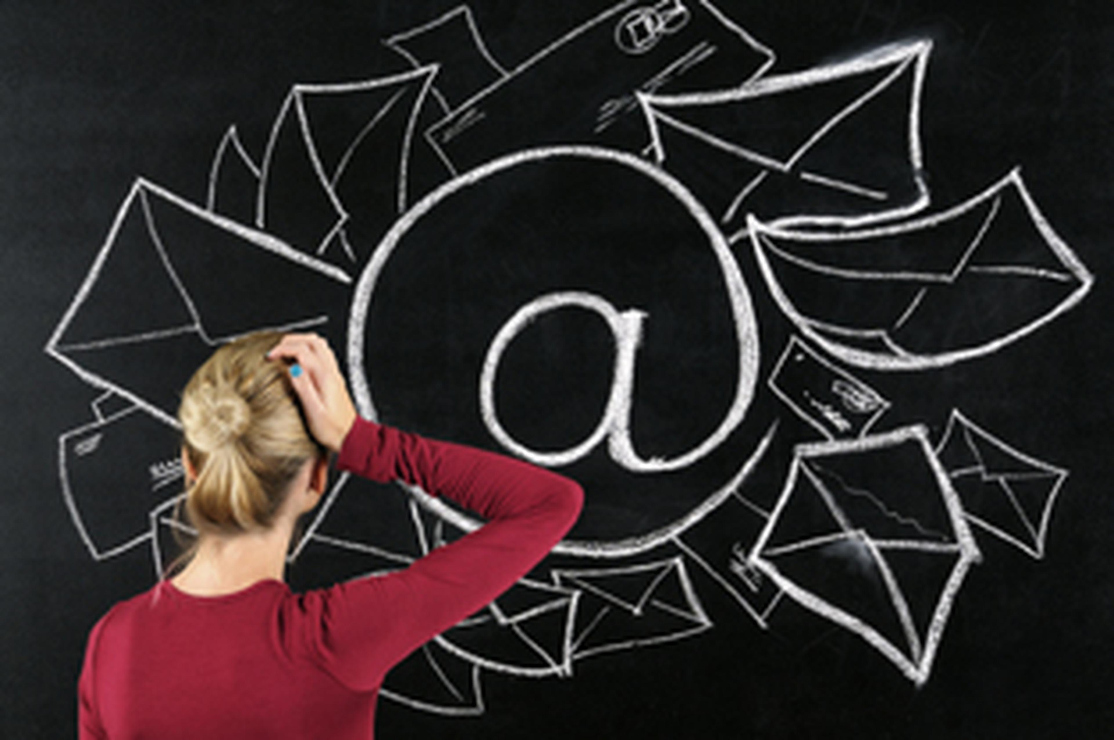 confused girl looking at an @ sign on chalkboard