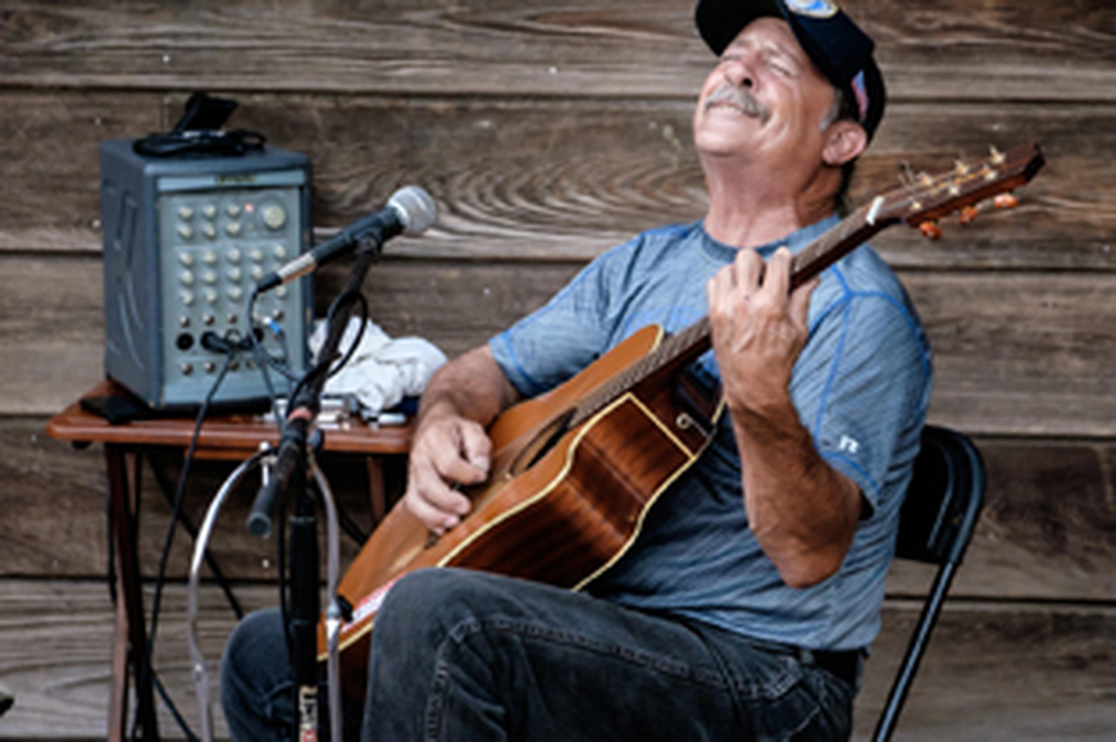 man performing with microphone and guitar