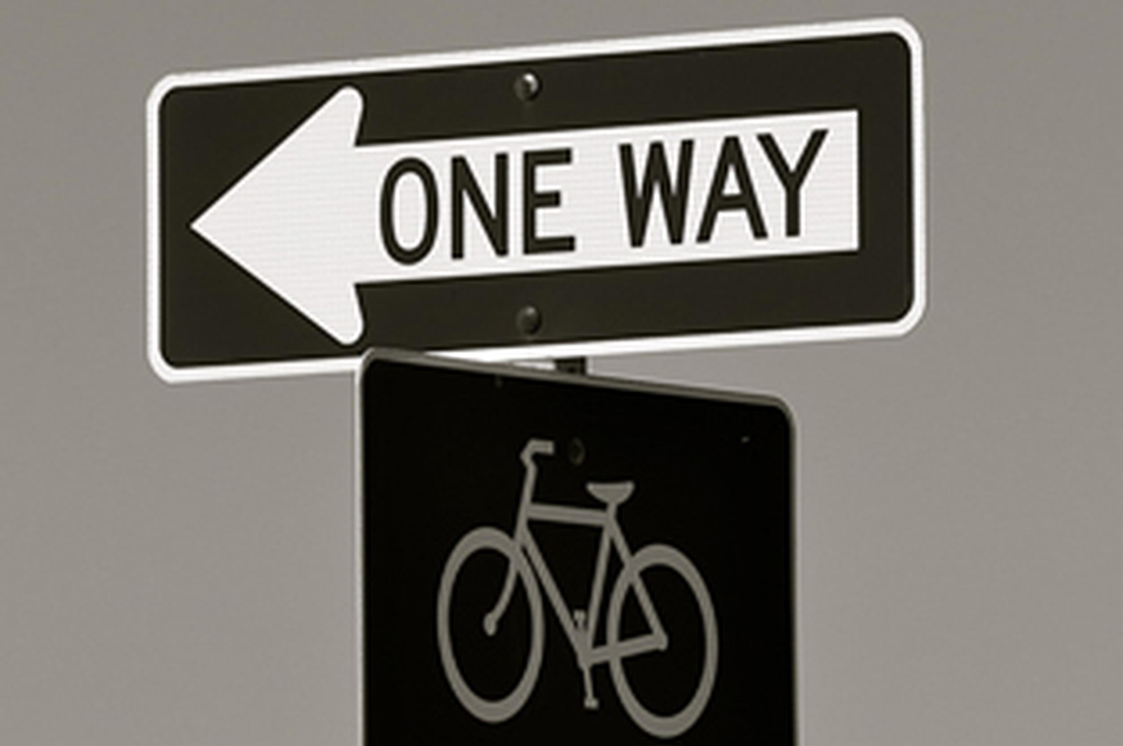 One Way and a Bicycle sign pointing in opposite directions