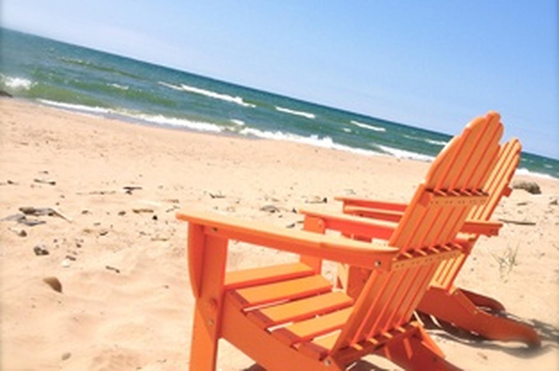 orange Adirondack chair on the beach