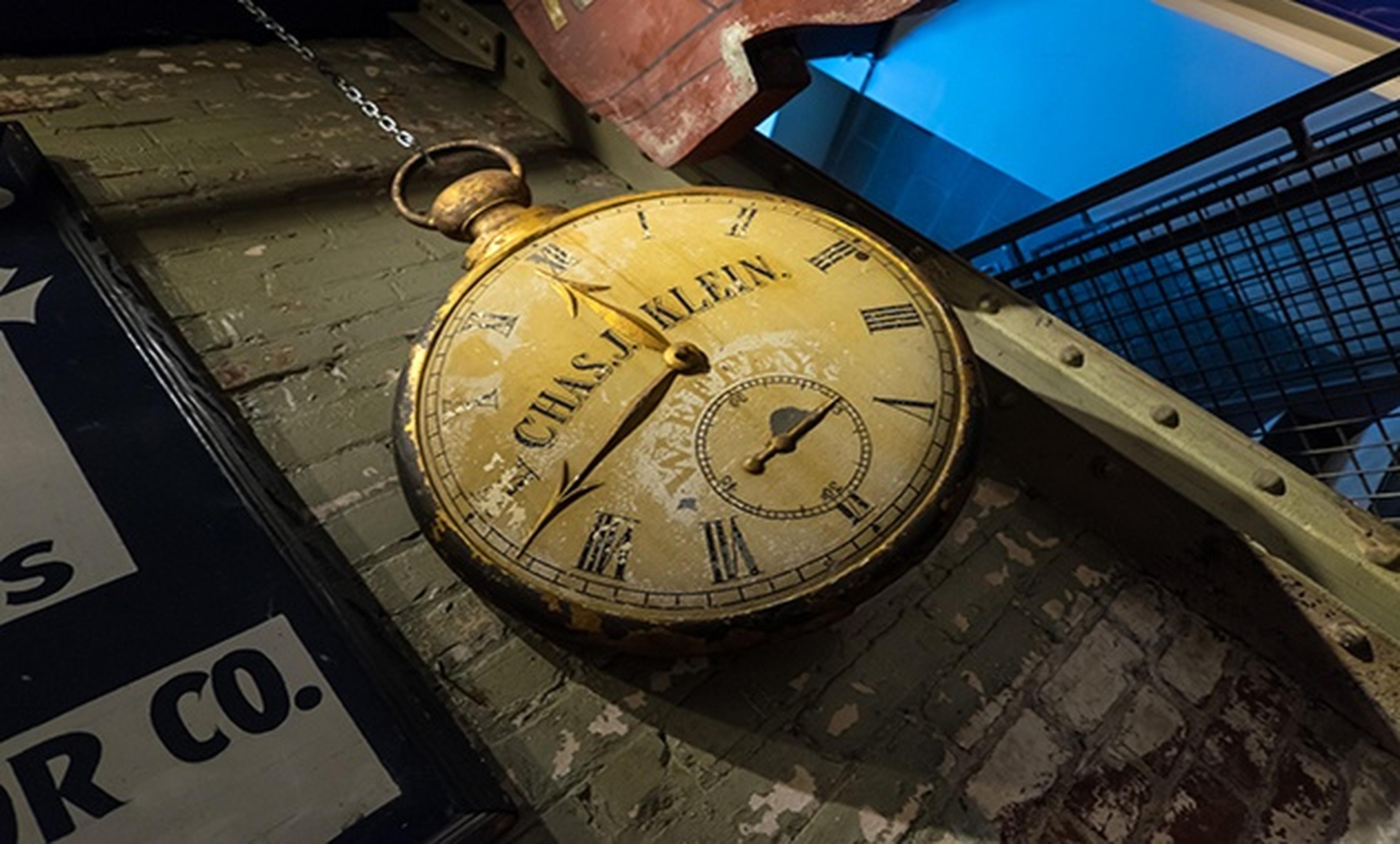 old pocket watch against green painted brick wall