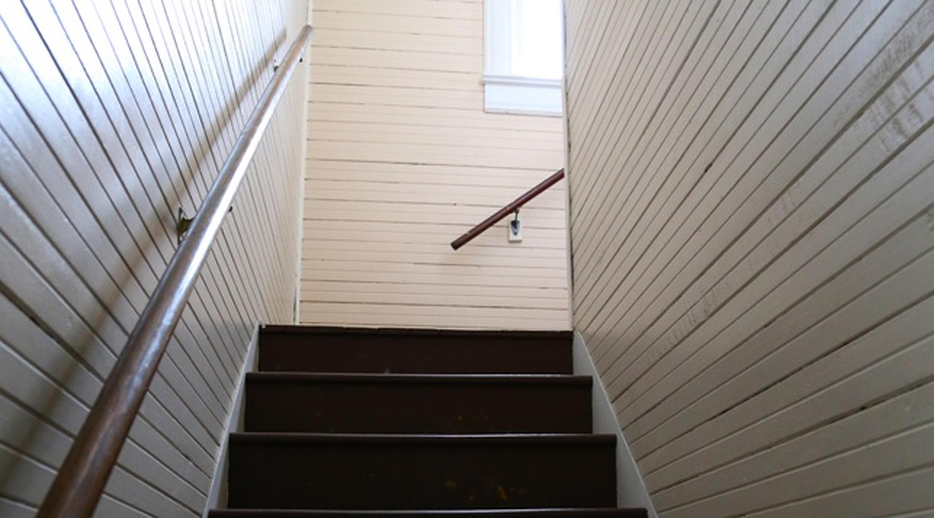 Brown staircase with wooden paneling on the walls