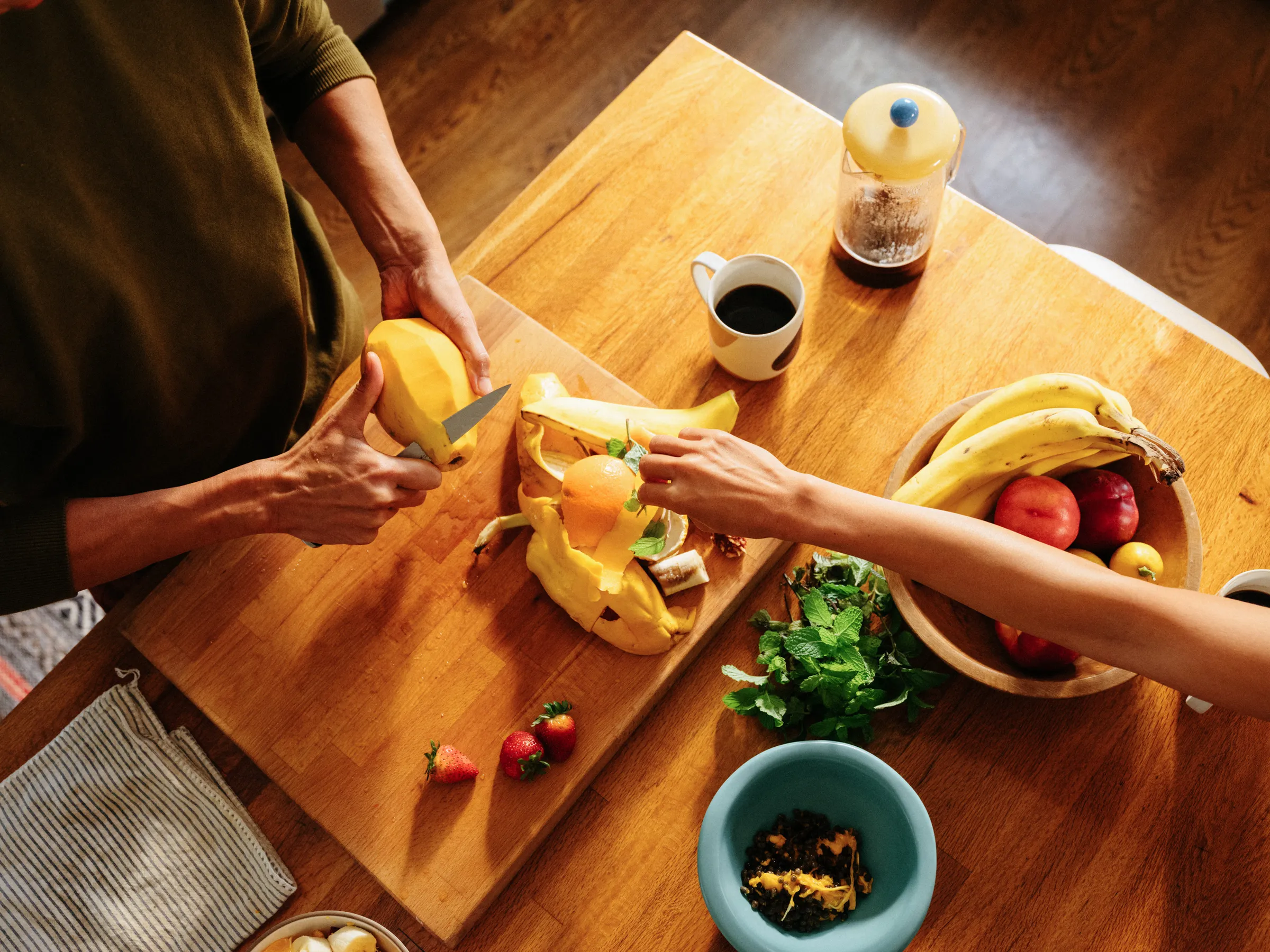 Food scraps being scraped from a cutting board into a Mill food recycler