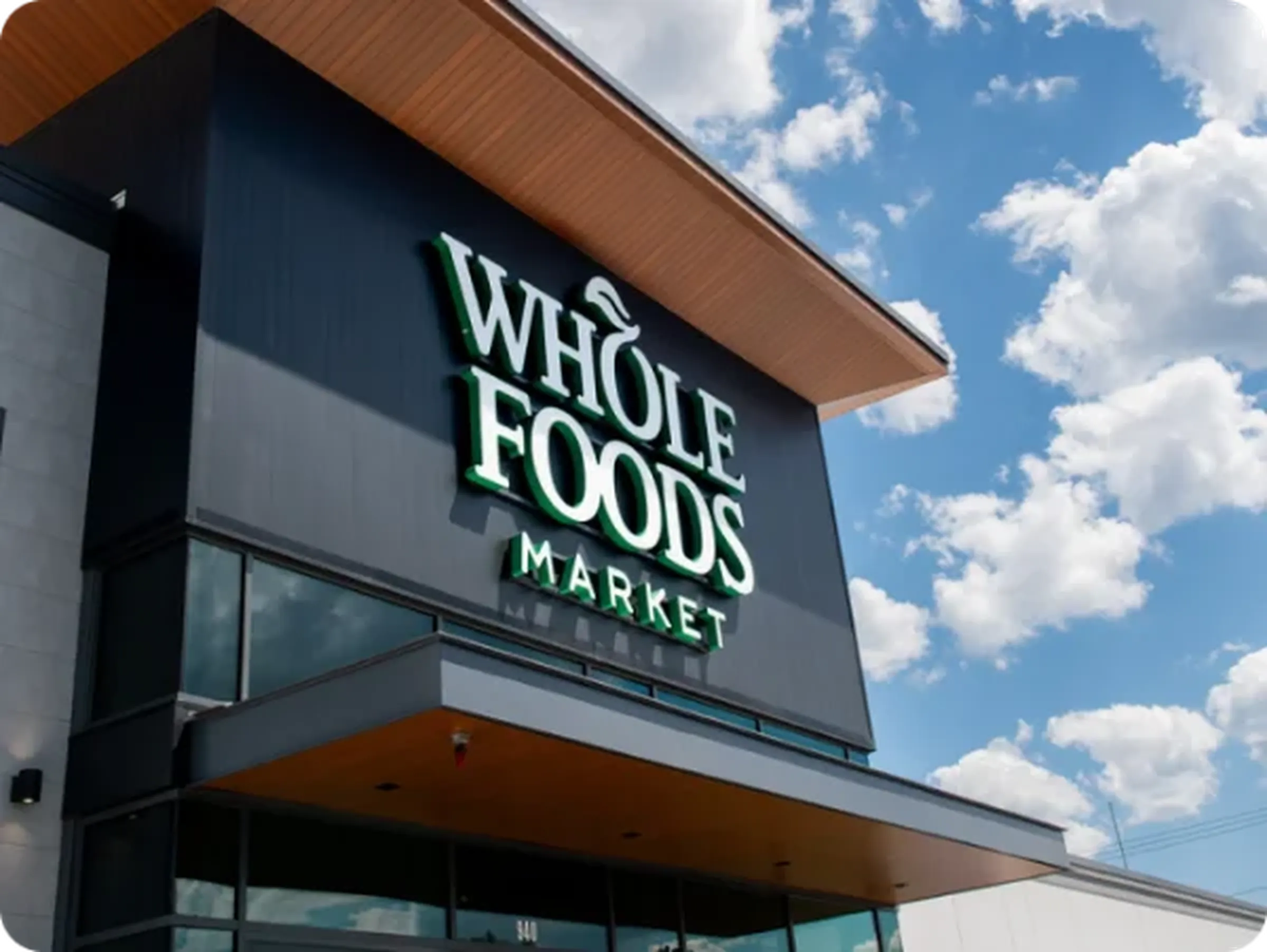 A Whole Foods Market storefront against a blue sky