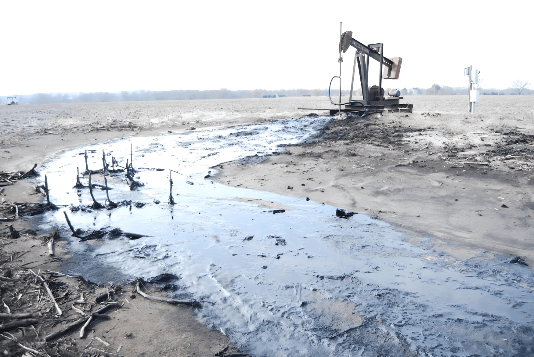 Oil spill near a pumpjack in a barren landscape, with dark oil pooling on the ground, creating an environmental hazard.
