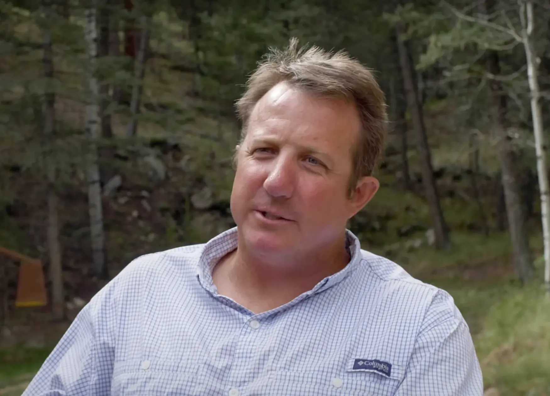 Tyler Mathews, CEO of Altitude Forestry, speaking outdoors in a forest setting