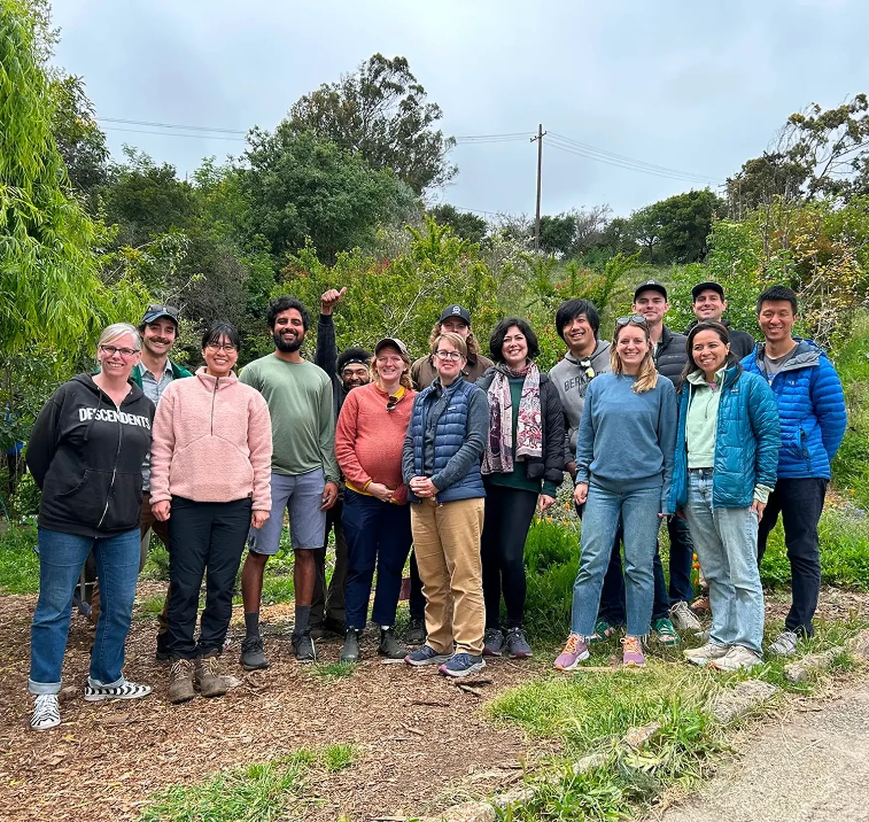 Group of diverse community members and Charm Industrial team standing together outdoors in a natural setting