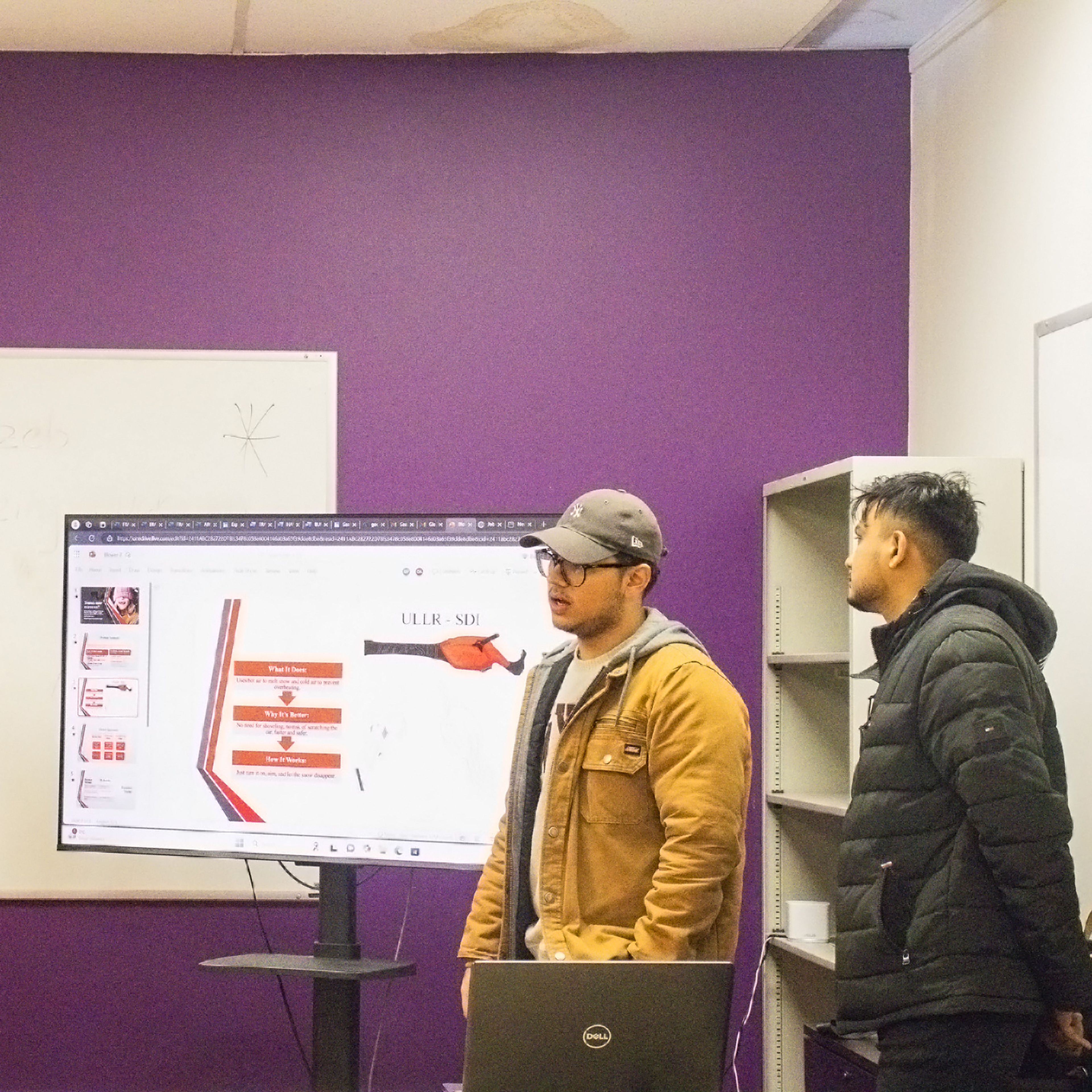 Individuals presenting in front of a screen.