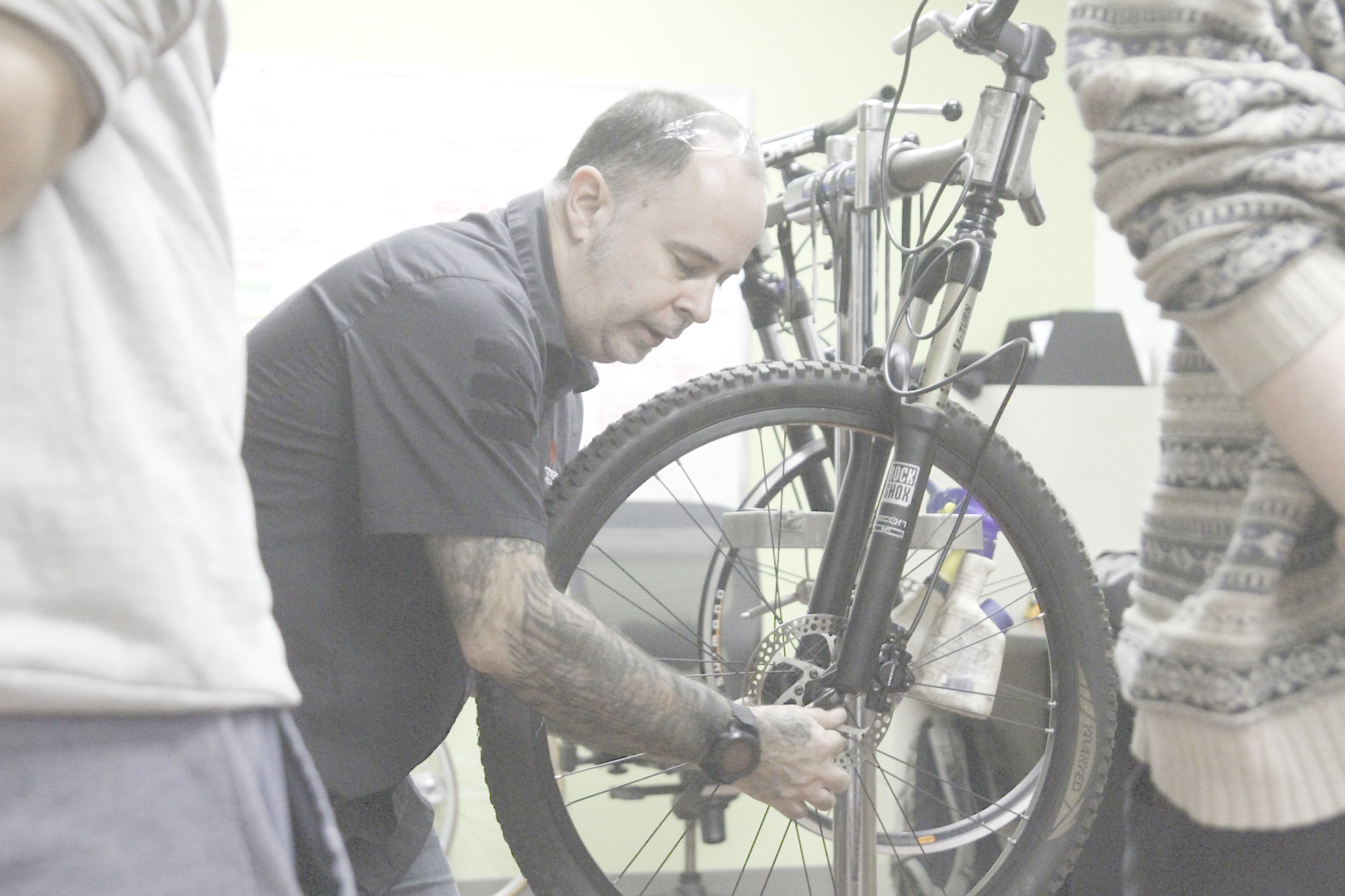 A man fixing the wheel on a bike.