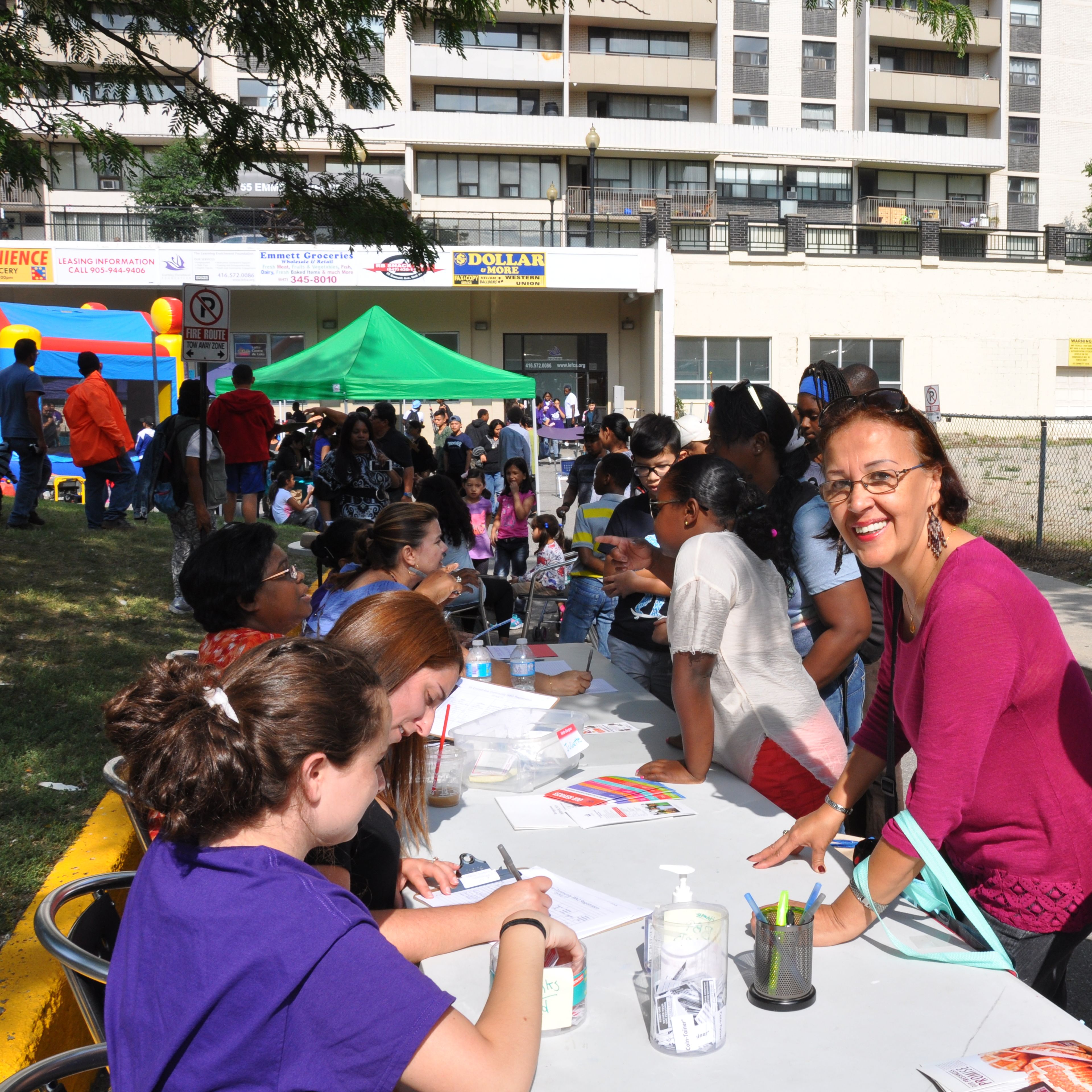 People registering for the Summer Program outdoors at 55 Emmett