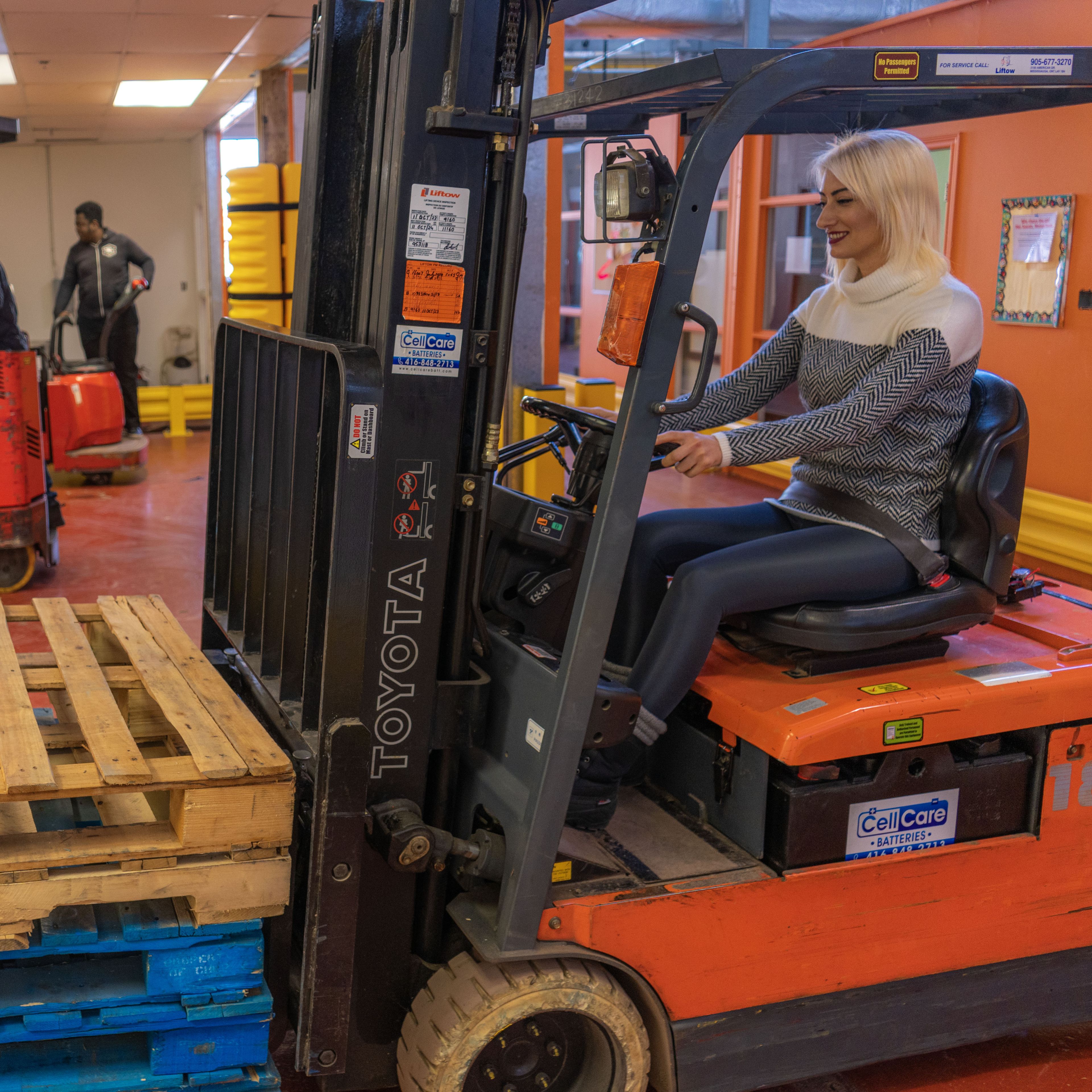 A person driving a fork lift.