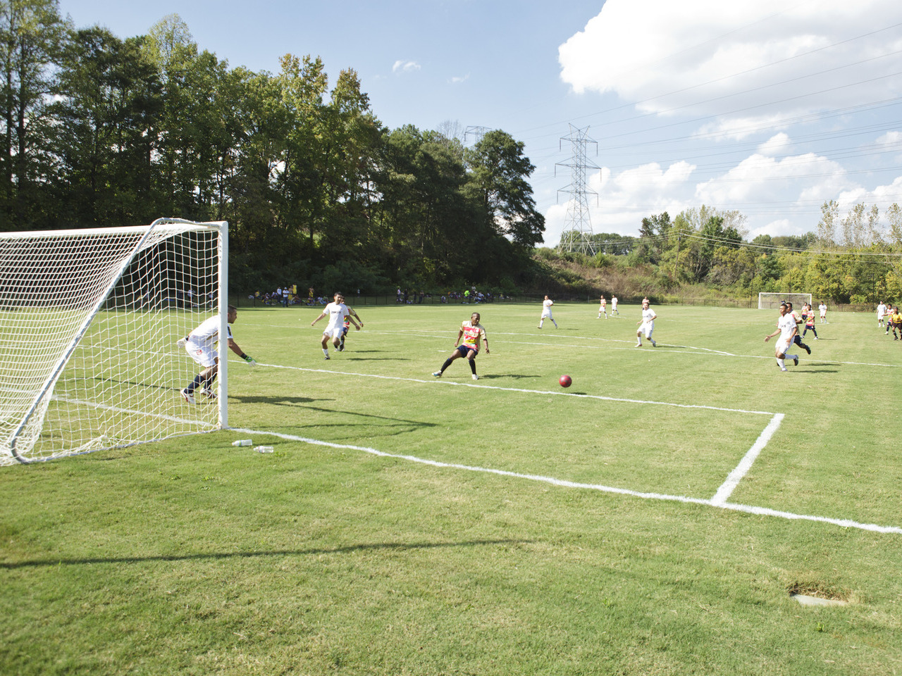 People play soccer on a sunny day.