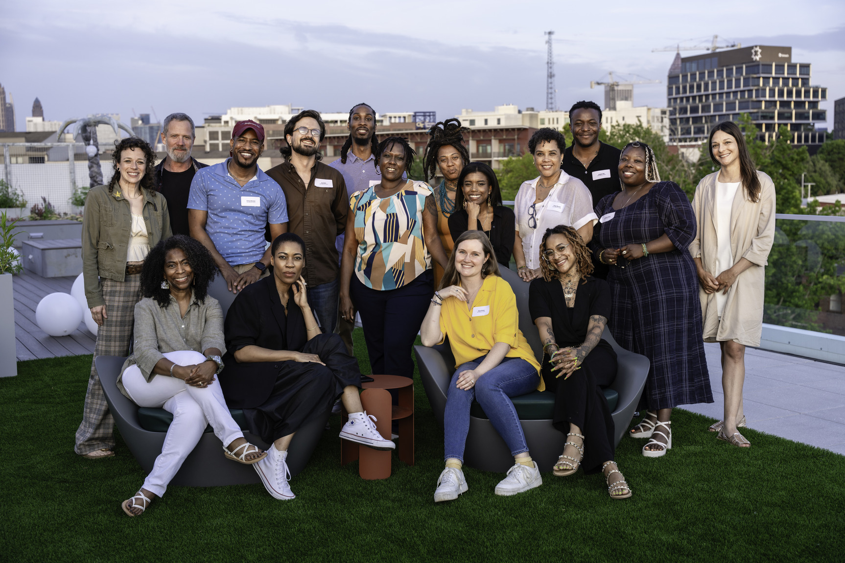 A group of artists pose together on a rooftop.