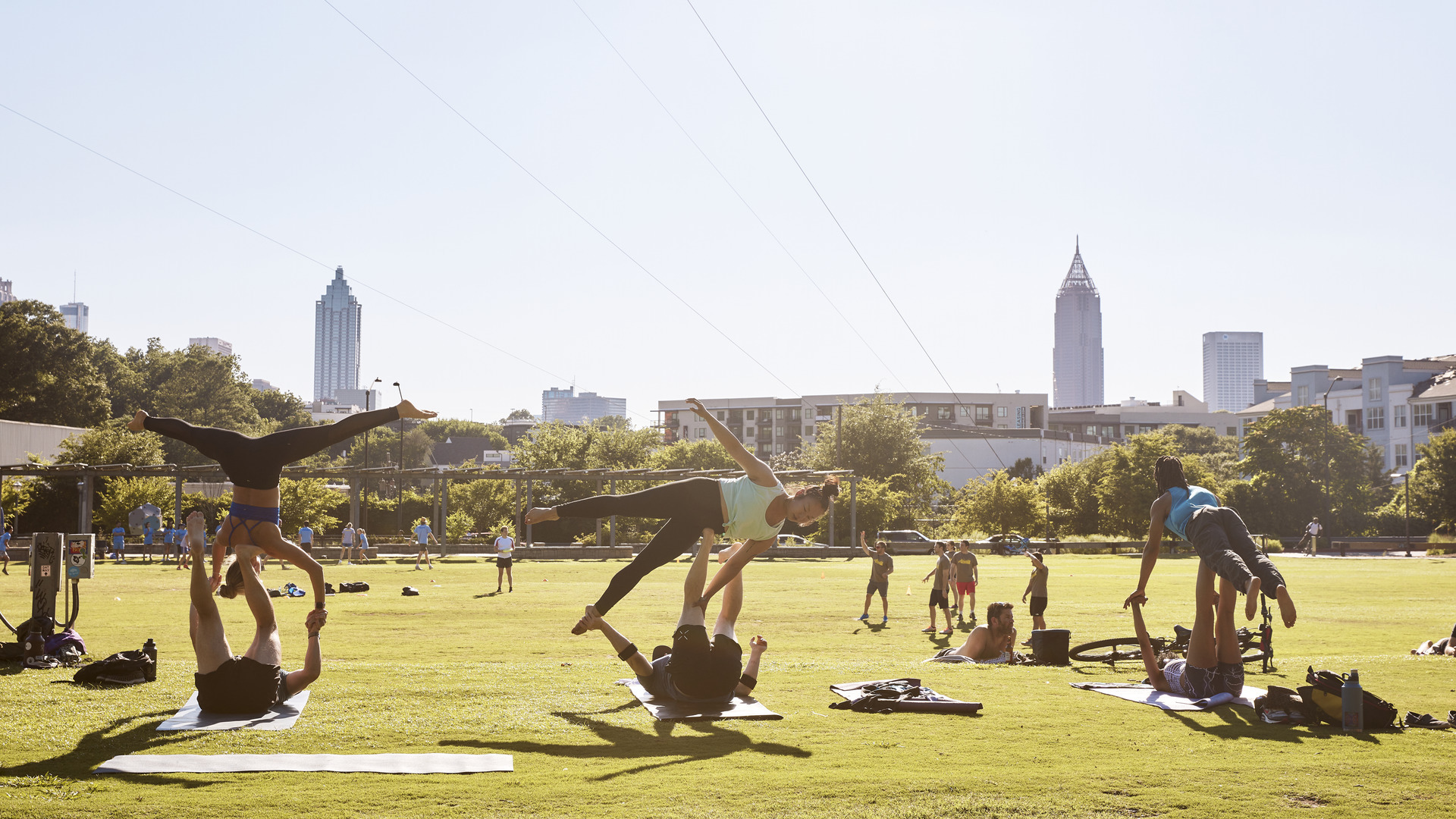 People participating in a yoga session amidst nature at a park.
