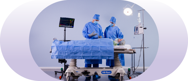 CRNA and anesthesiologist in OR with anesthetized patient on the operating table.