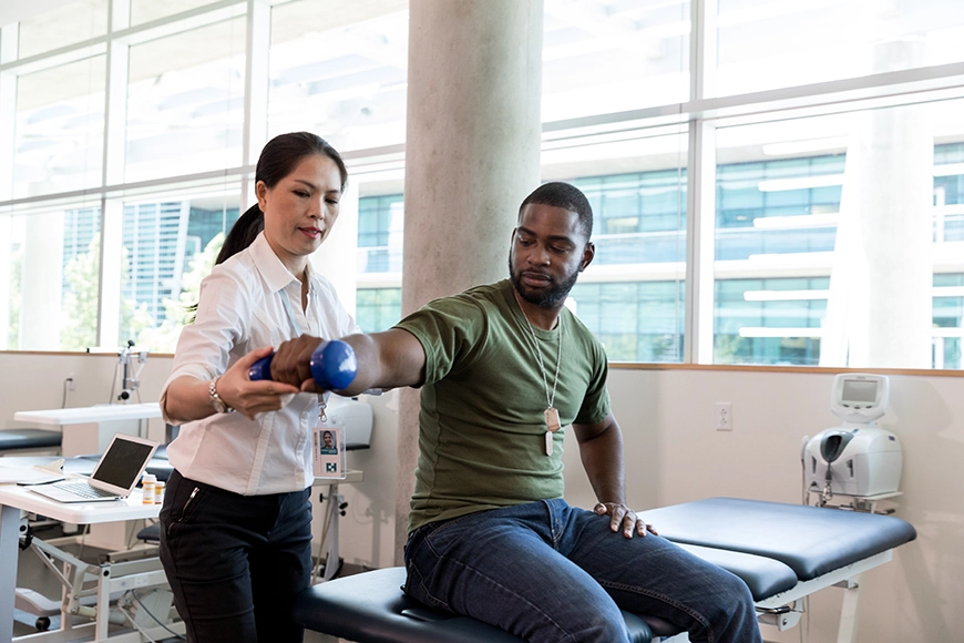 Physical therapist works with a patient in a therapy room