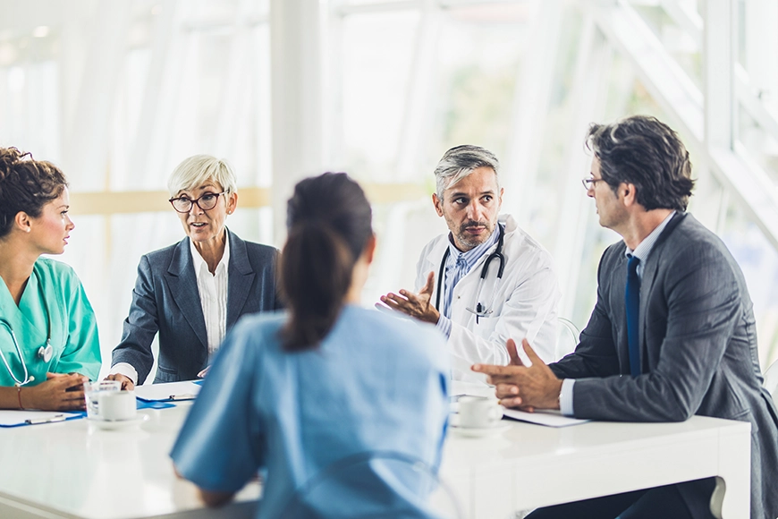 Groupd of healthcare executives speaking in boardroom