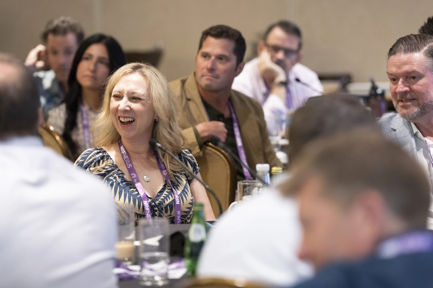 A woman at NRF Nexus laughs during a presentation.