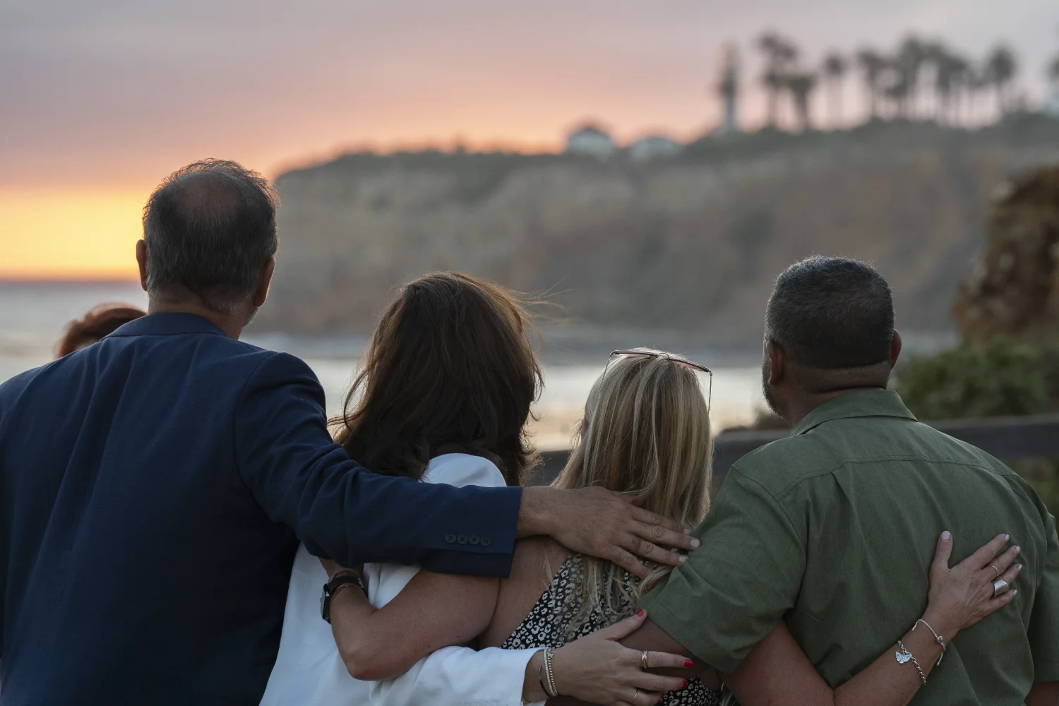 Four Nexus attendees put their arms around one another's shoulders to reflect on their conversations at Nexus while watching the gorgeous seaside sunset.