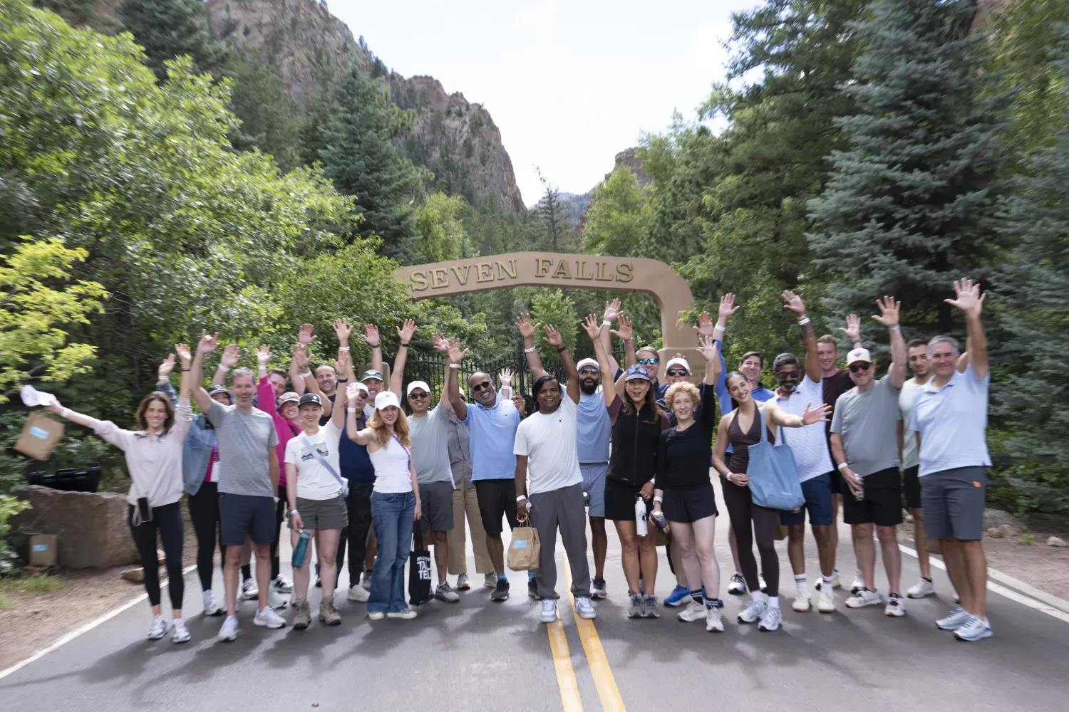 NRF Nexus attendees raise their hands in the air at the finish of the optional group hiking activity.