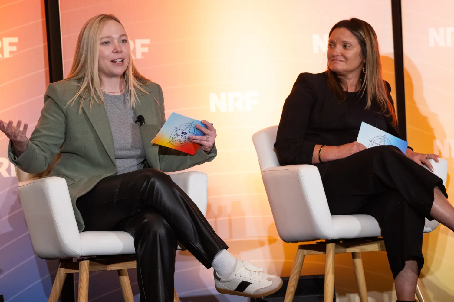 Two women, sitting on stage at NRF PROTECT, engage the audience in a discussion about loss prevention in the retail industry.