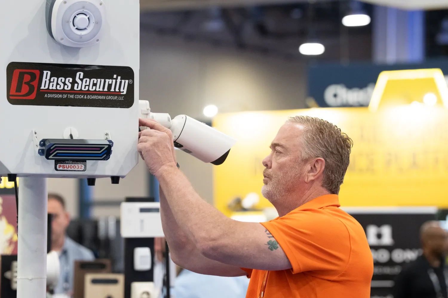 Person adjusting a mounted surveillance camera on a display at a NRF PROTECT expo.