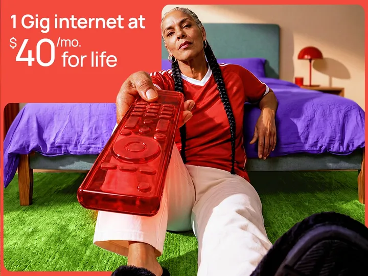 A confident woman sits on a green rug holding a red remote. Text: 1 Gig internet at $40/month for life.