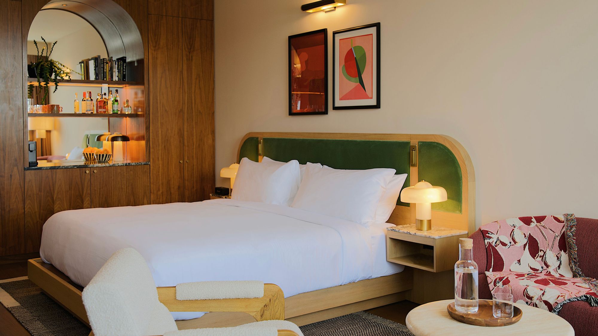 Municipal Grand Hotel, Savannah, GA. Stylish hotel room with a large bed, modern decor, wall art, a minibar, and seating area. wooden accents create a cozy ambiance. king bed ADA Municipal Grand Savannah GA