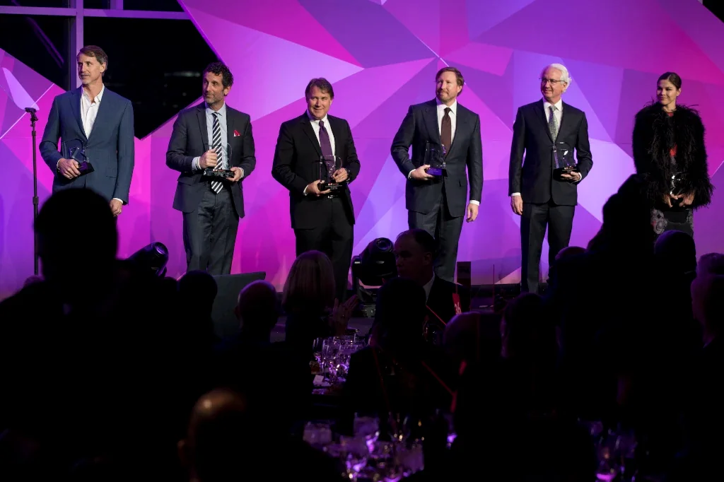 Six NRF Foundation Honors honorees stand on stage, smiling and holding their awards.