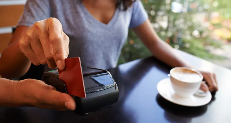 credit card swipe to pay for a coffee shop purchase