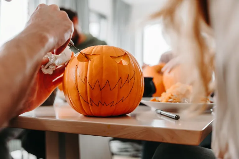A person carving a pumpkin.