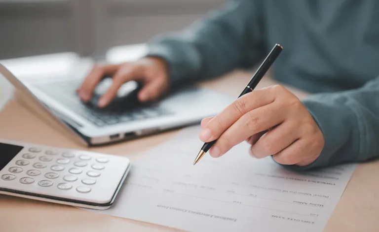 A person writing with a pen.