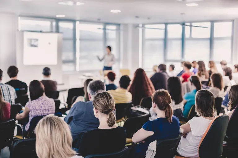 A person giving a speech to a crowd of people.