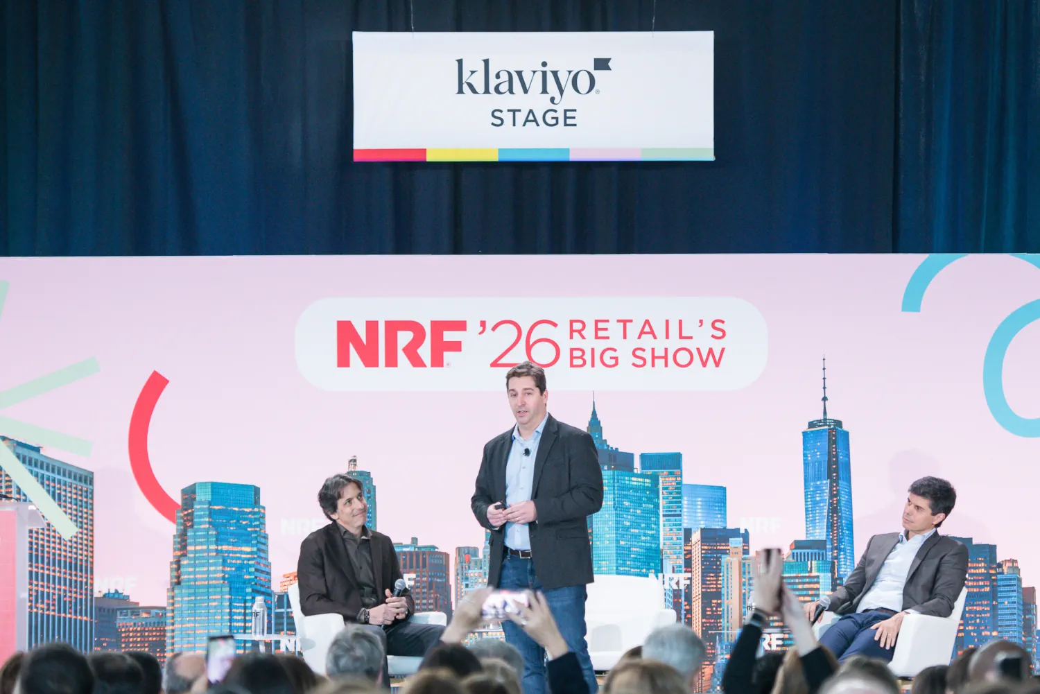 Gui Serrano speaks while standing from the klaviyo Stage at NRF'26.