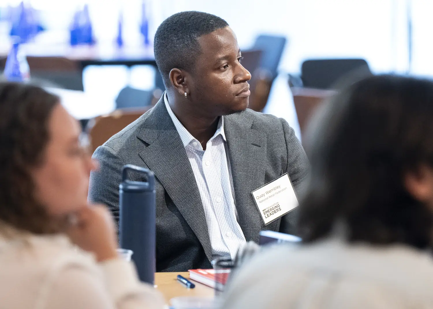A NRF Foundation Emerging Leaders 2026 Summit attendee listens intently while seated at his roundtable.