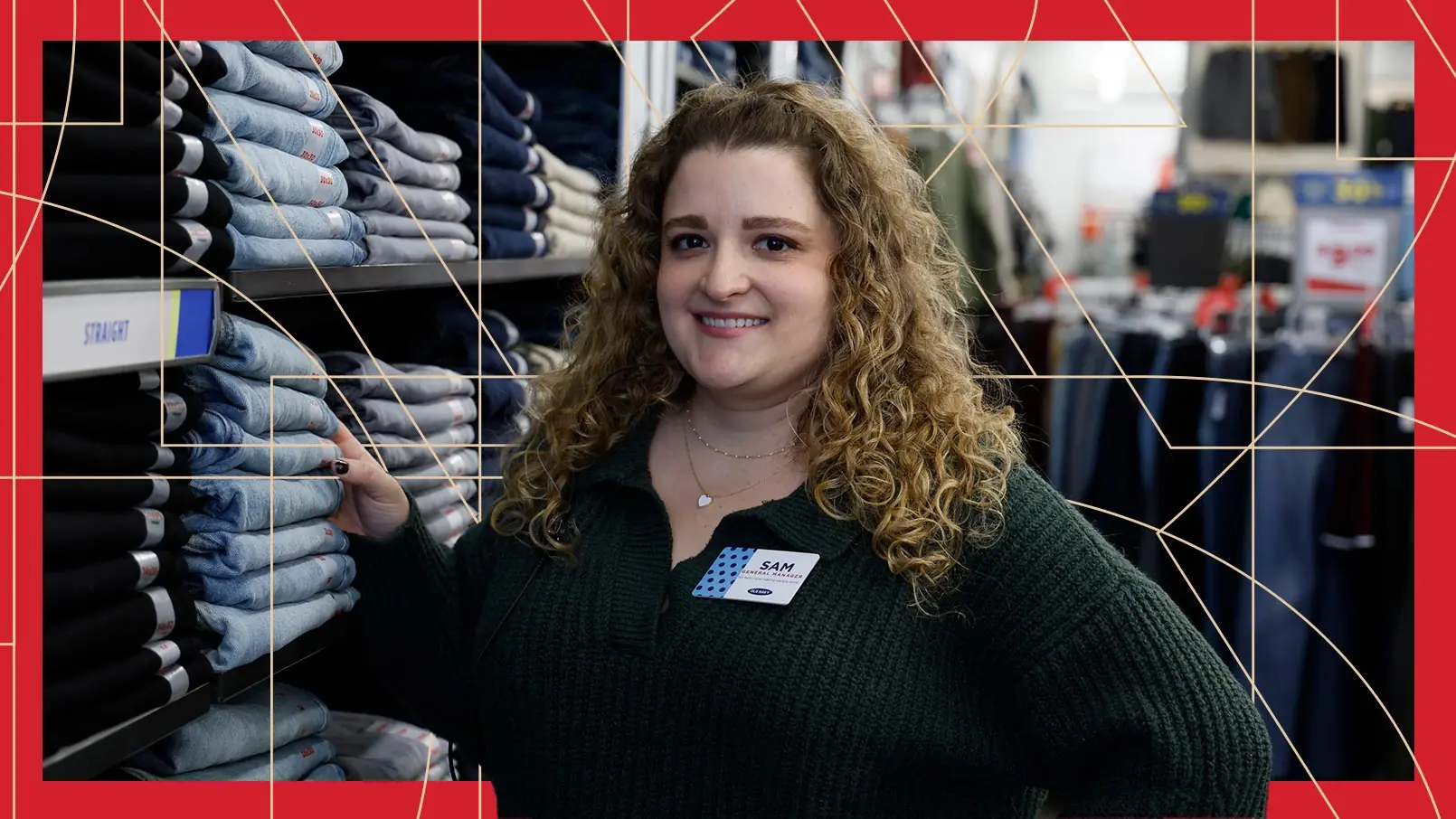General Manager Samantha Feierabend poses alongside shelves stacked with denim jeans in an Old Navy store. The photo has a red border and thin, gold, and geometric lines running through the background.