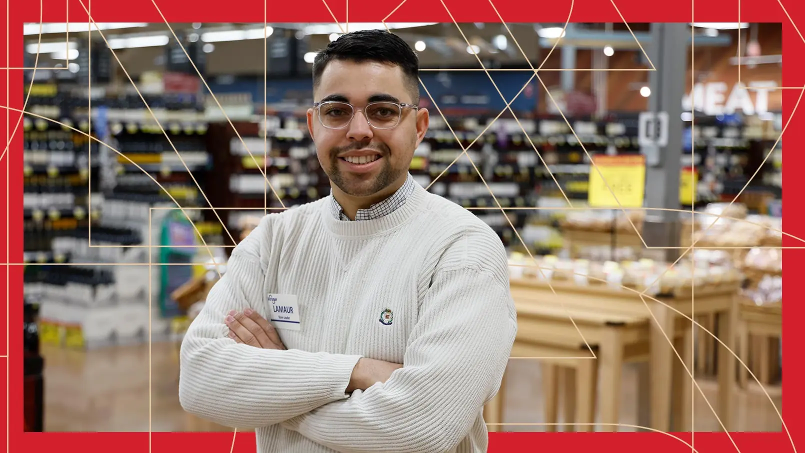 Kroger Store Leader Lamaur Buck proudly poses in front of his grocery store. The photo has a red border and thin, gold, and geometric lines running through the background.