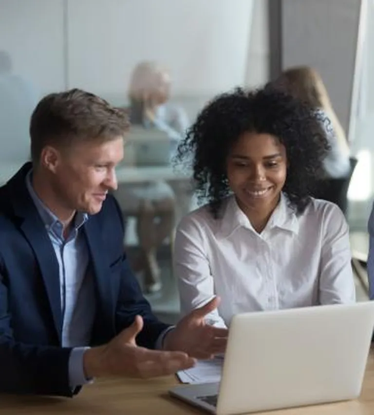 A man and women sitting in front of a laptop