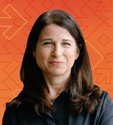 A profile photo of Julie Bornstein, overlayed over an orange background with a geometric pattern of arrows and diamond shapes.