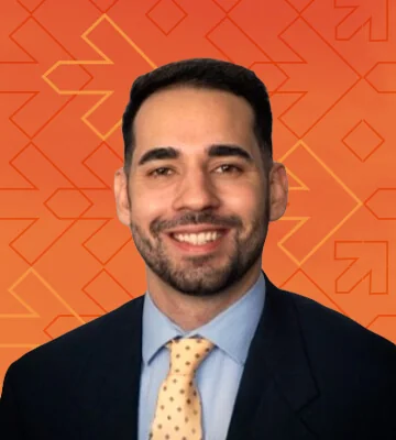 Professional portrait of Cody Villaneuva. The photo's background has a gradient of orange and red colors along with arrows pointing right, consistent with the NRF Foundation Student Program branding.