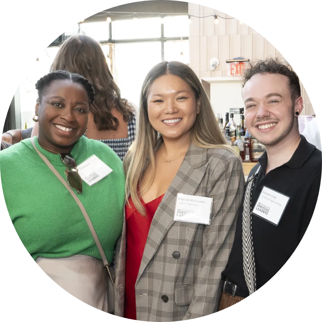 A group of young retail leaders pose with broad smiles during a reception at a professional development conference.