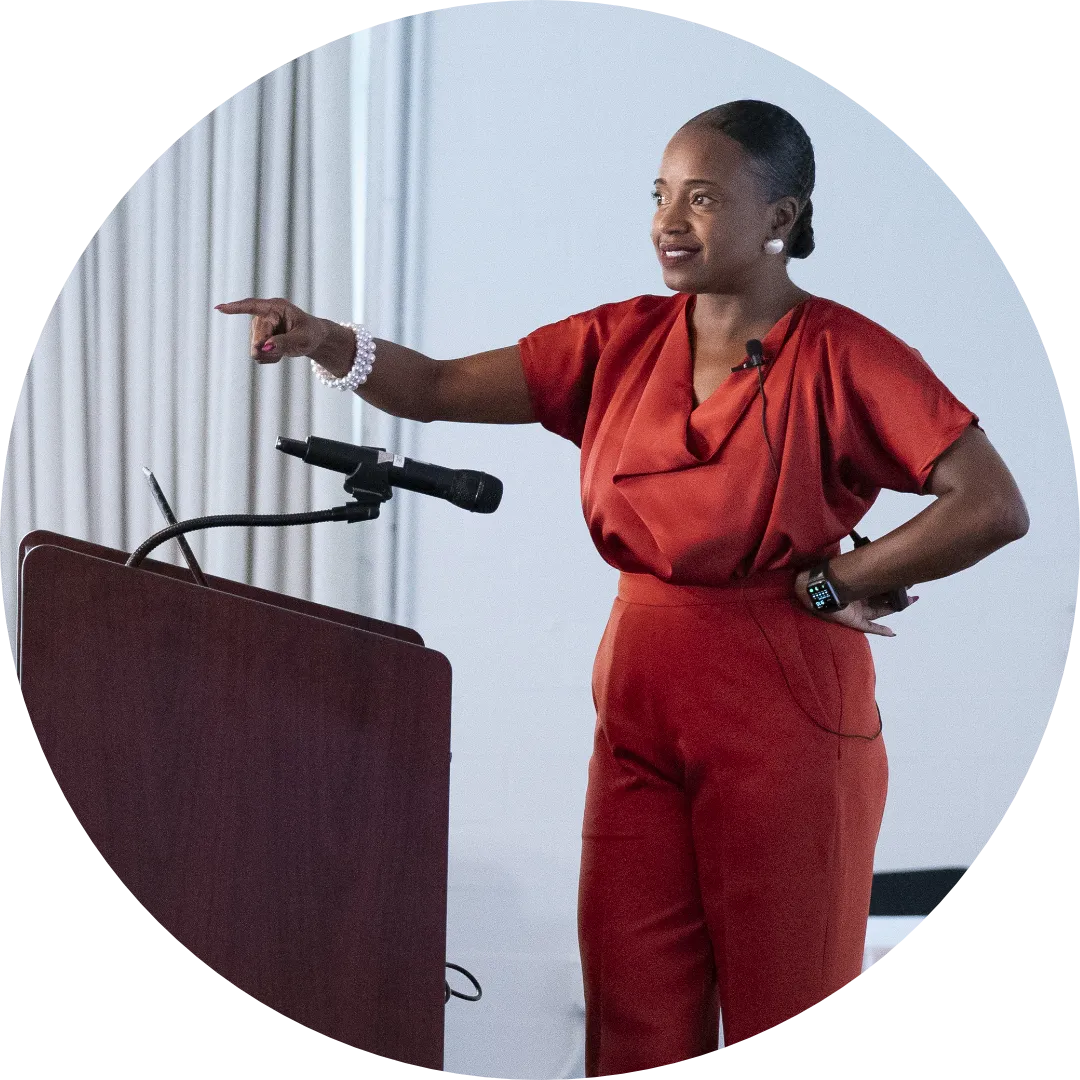 A woman standing at a lecturn gives expert retail career advice to a group of the industry's future leaders.