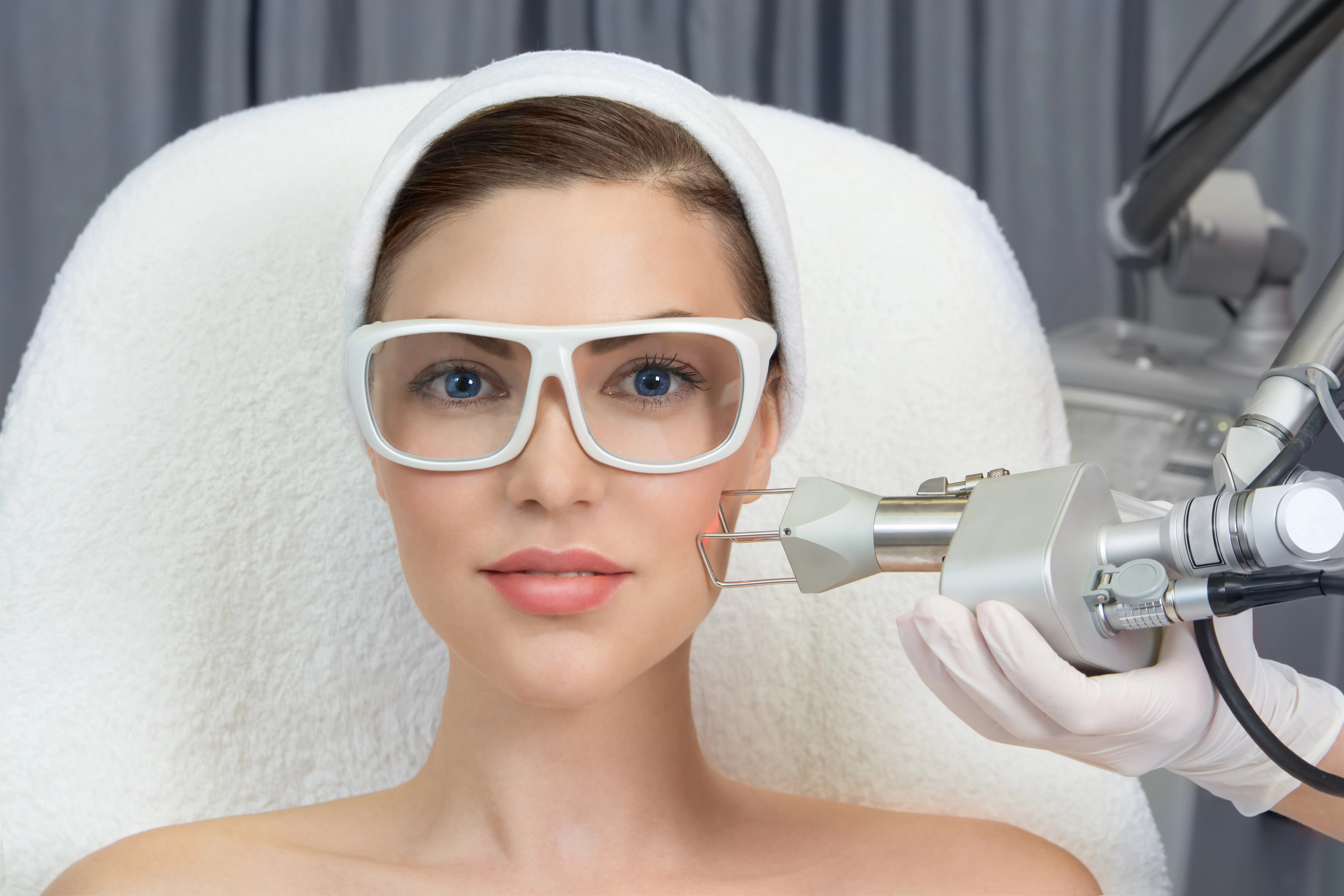 Women in protective white glasses with blue eyes relieving CO2 treatment