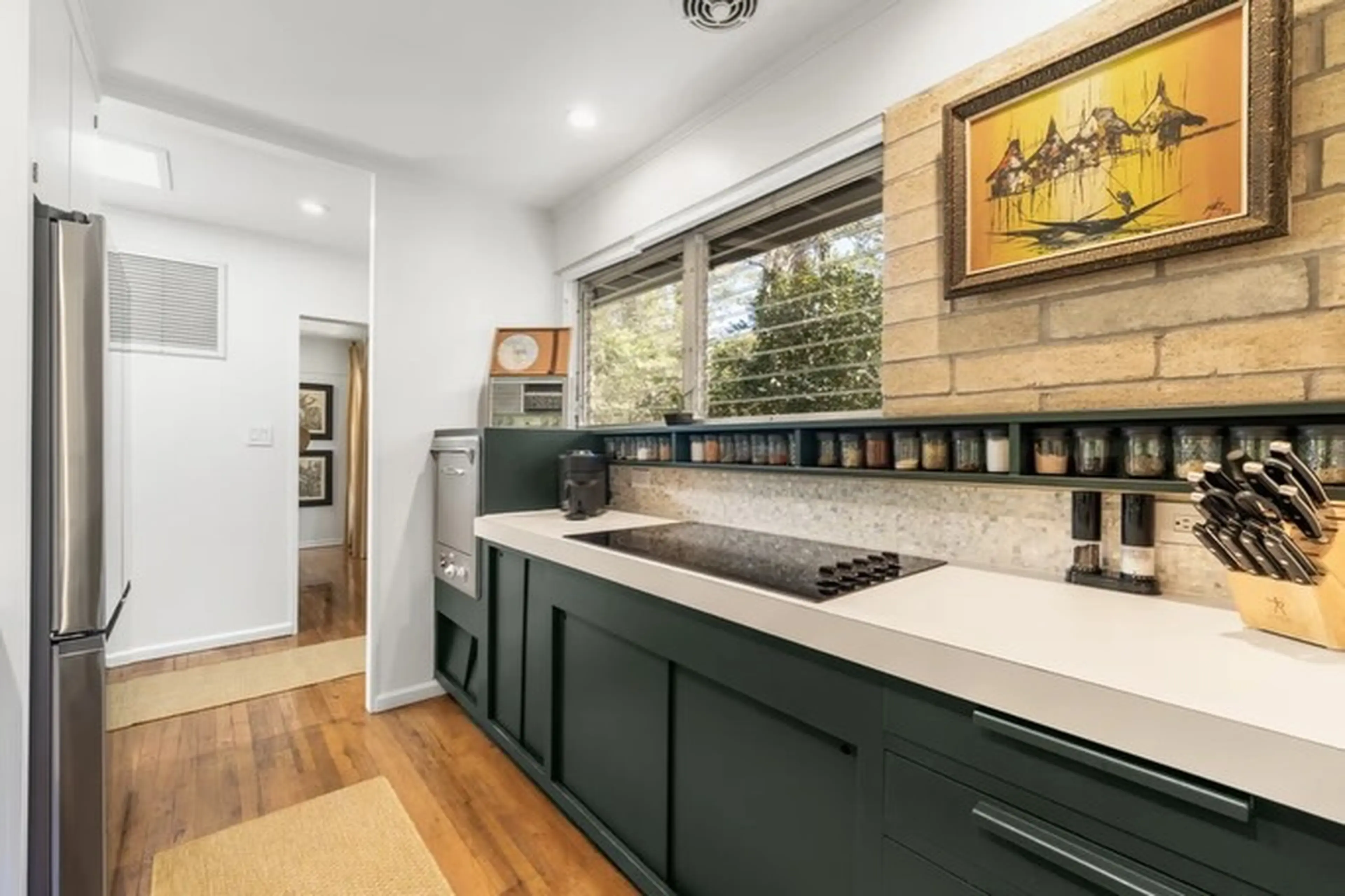 Inside kitchen with wood floors and brick wall