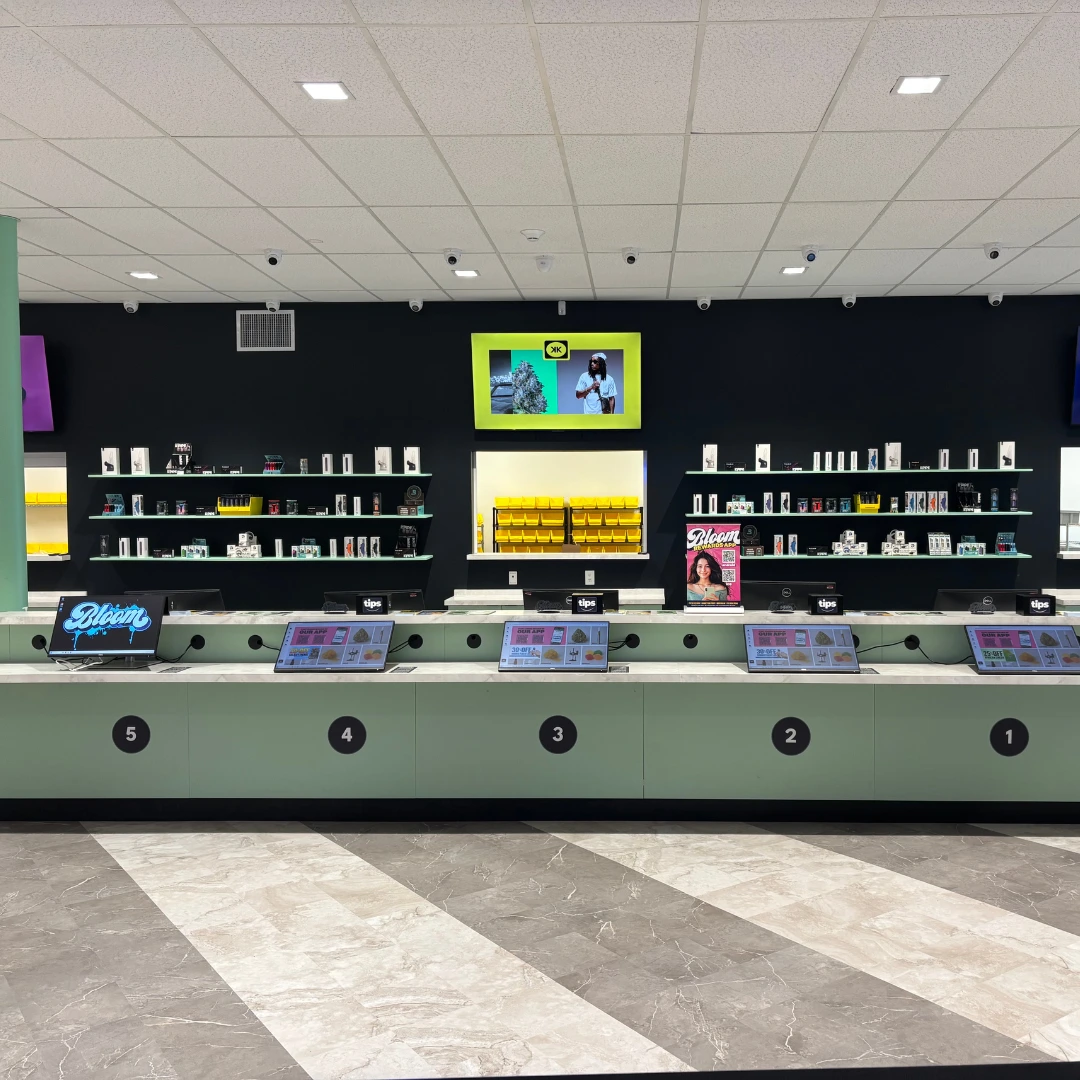 Bloom cannabis Massillon dispensary instore counter with product menu screens and accessory wall full of vape batteries,  glass pipes, grinders