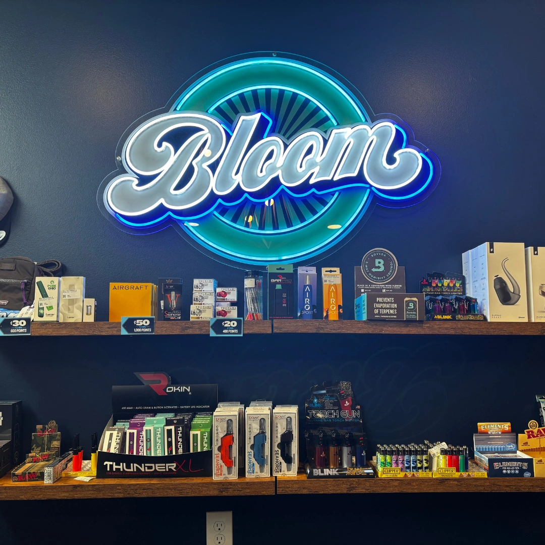 Bloom cannabis Akron dispensary accessory shelf with a variety of lighters, vape batteries, raw rolling papers and more.