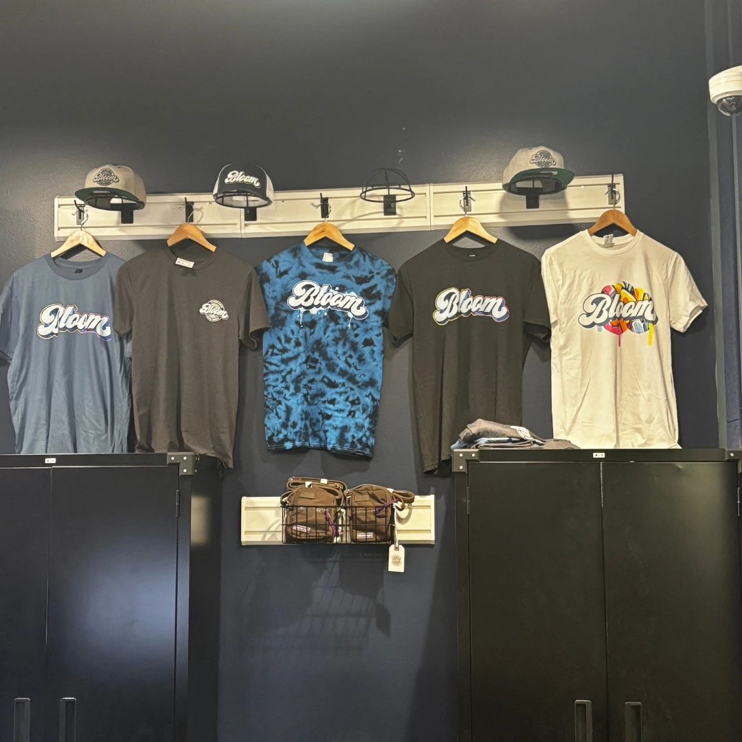 Bloom cannabis Akron dispensary apparel wall with branded t-shirts