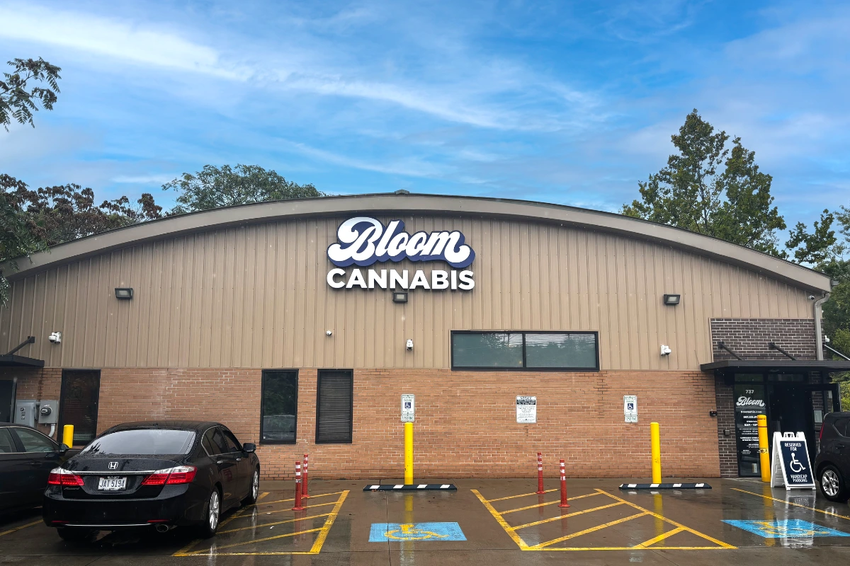 Bloom Cannabis Akron dispensary storefront exterior with building signage and accessible parking spaces.